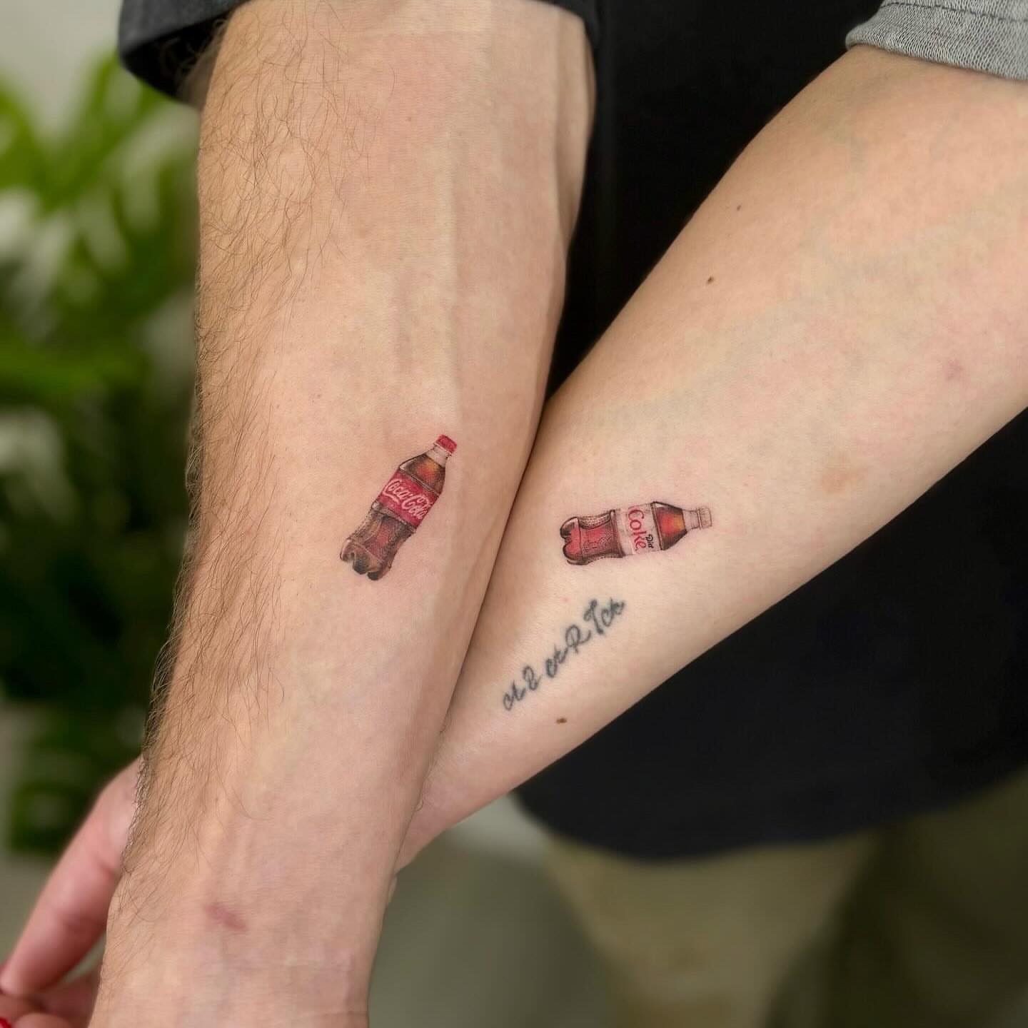 Coca-Cola bottle realism tattoo on the forearm by Nina