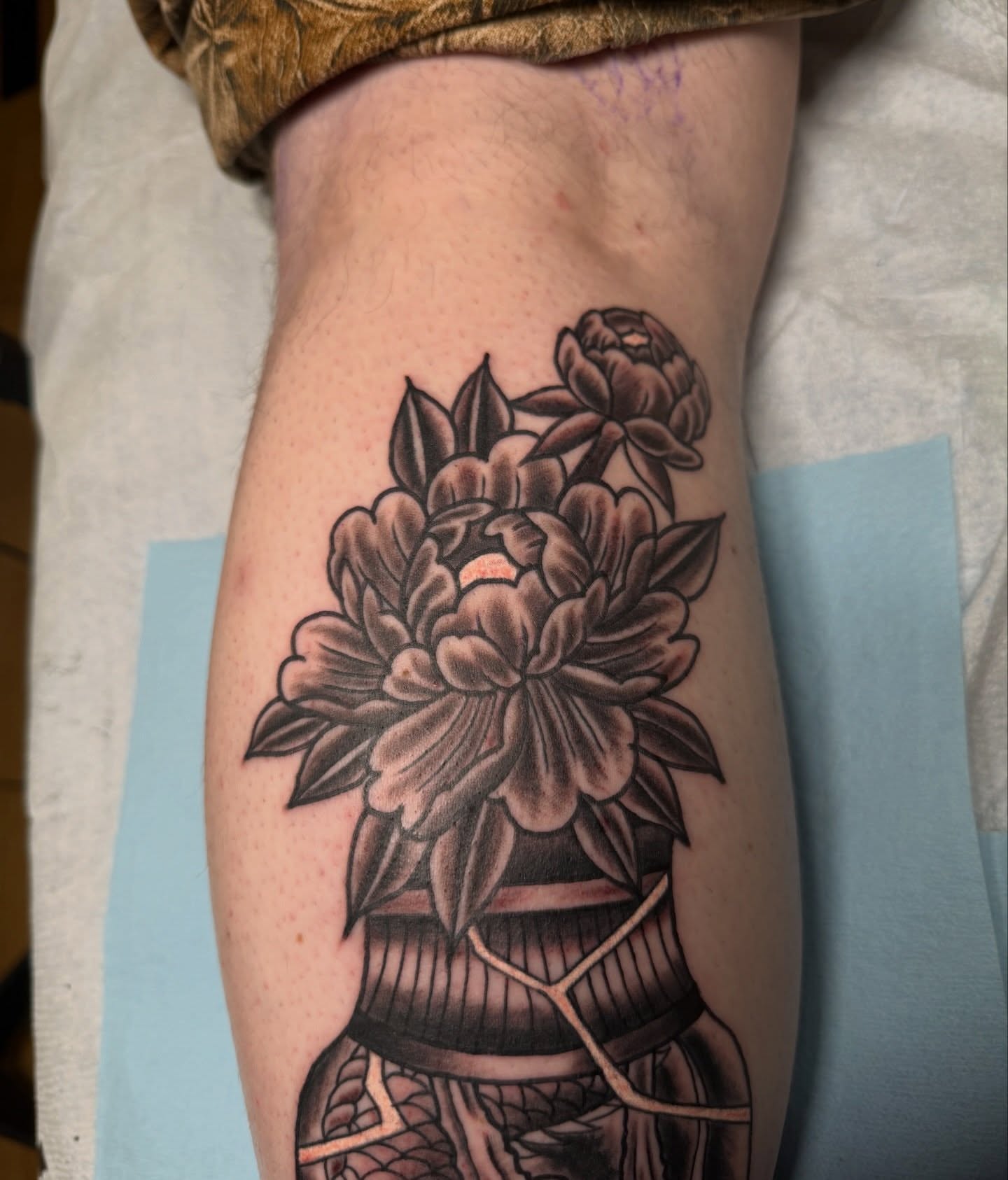 Peony bouquet black and grey tattoo on the forearm by Trevor Berry