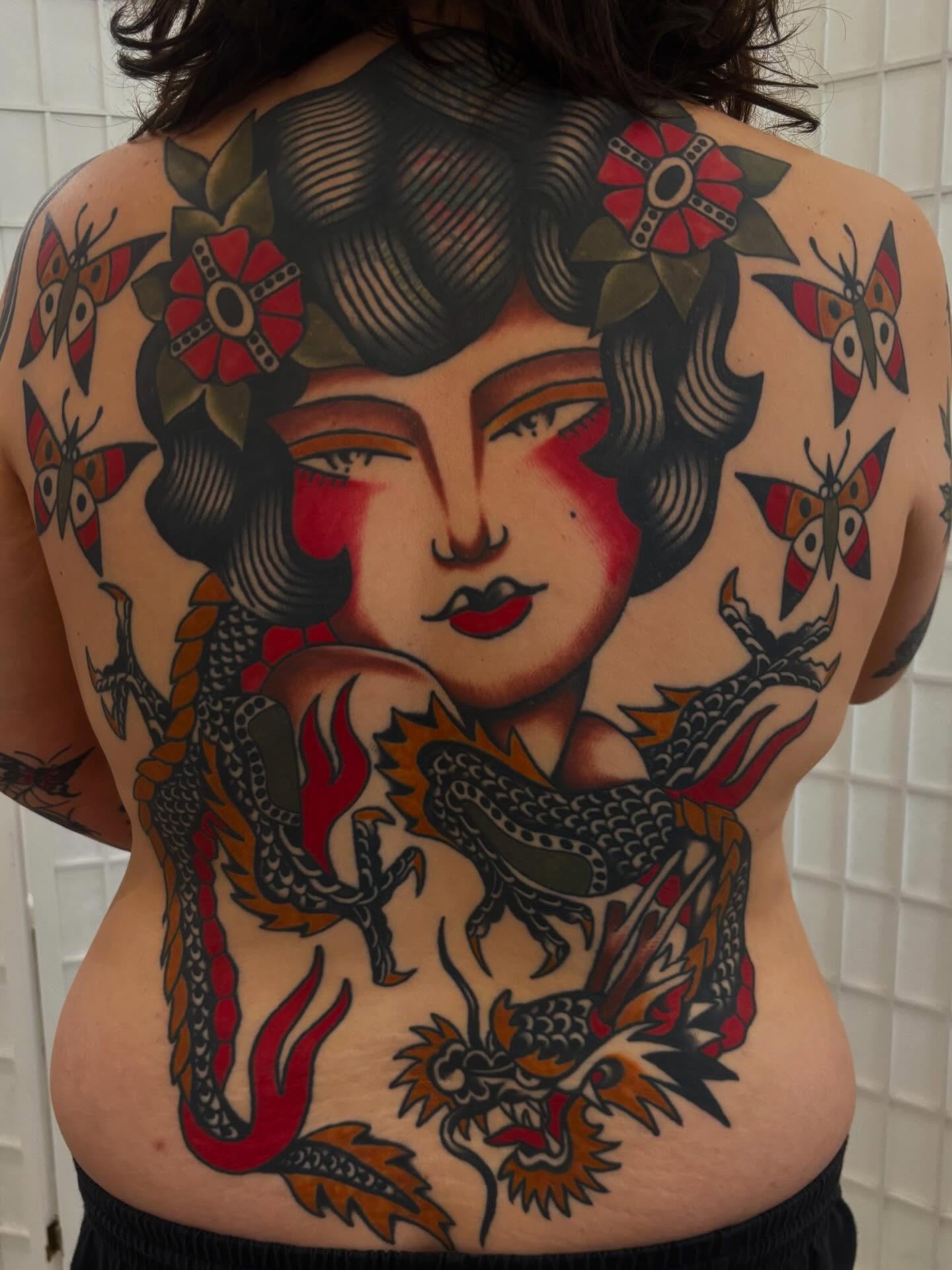 Woman with dragon American traditional tattoo on the back by Claire Anderson