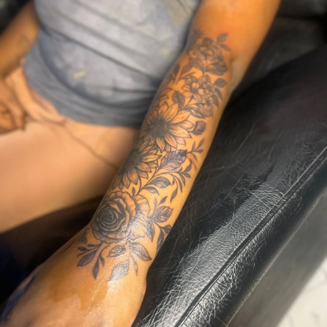 Floral sleeve with roses and sunflowers ornamental tattoo on the forearm by Mwangaza Bodyworks, Uthiru, Nairobi Area, Kenya