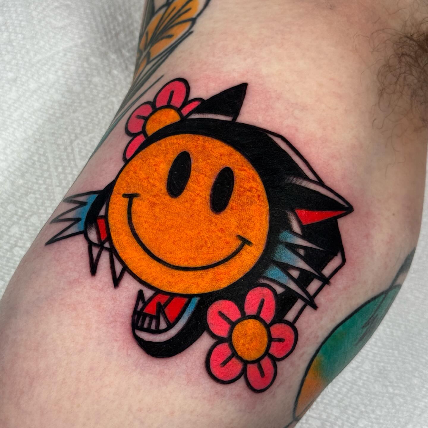Smiley face American traditional tattoo on the forearm by Jess Baker