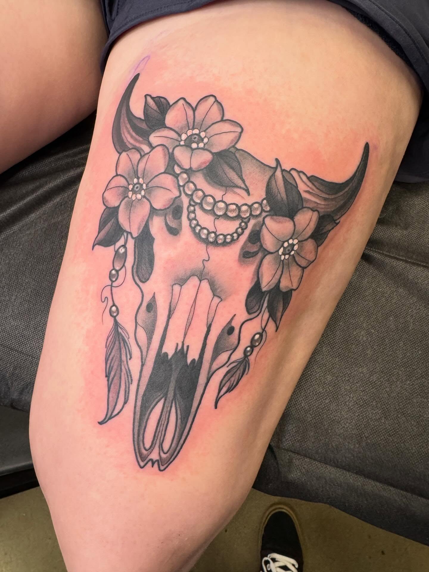 Bull skull with flowers ornamental tattoo on the thigh by Jess Longfield, Des Moines, Iowa