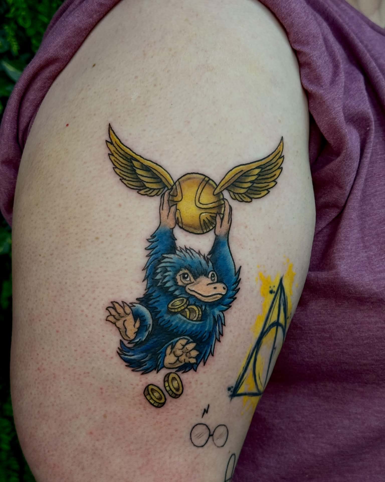Golden snitch and bludger illustrative tattoo on the shoulder by Sabrina