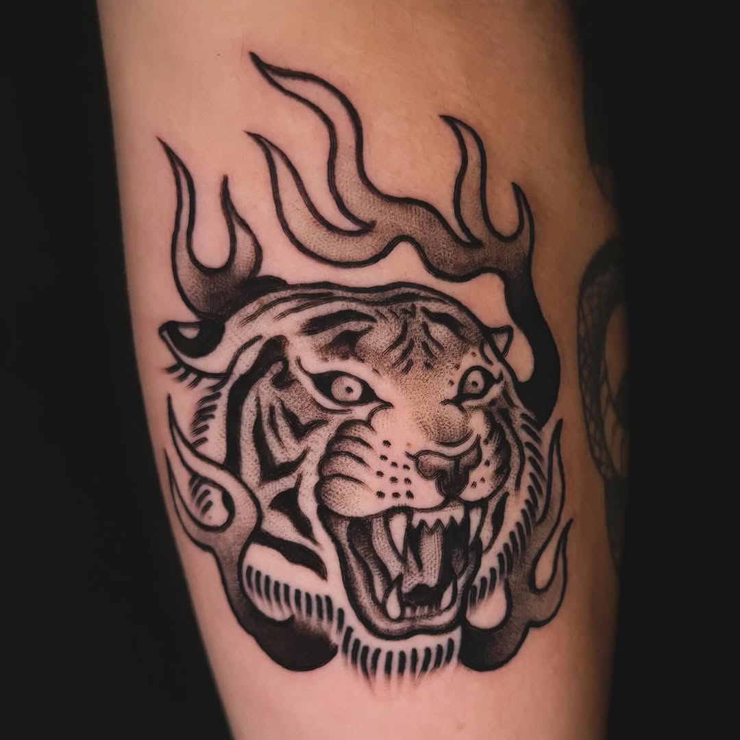 Tiger head with flames realism tattoo on the forearm by Nikki Bee