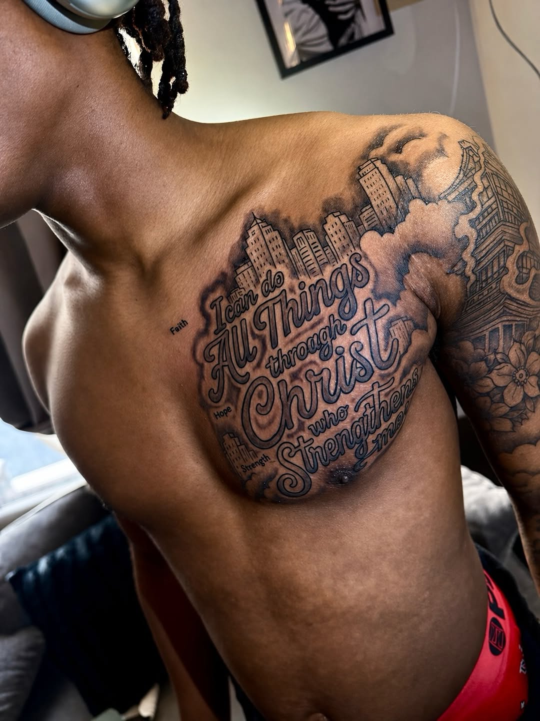 Religious text with cityscape Chicano tattoo on the chest by JayyeSosa