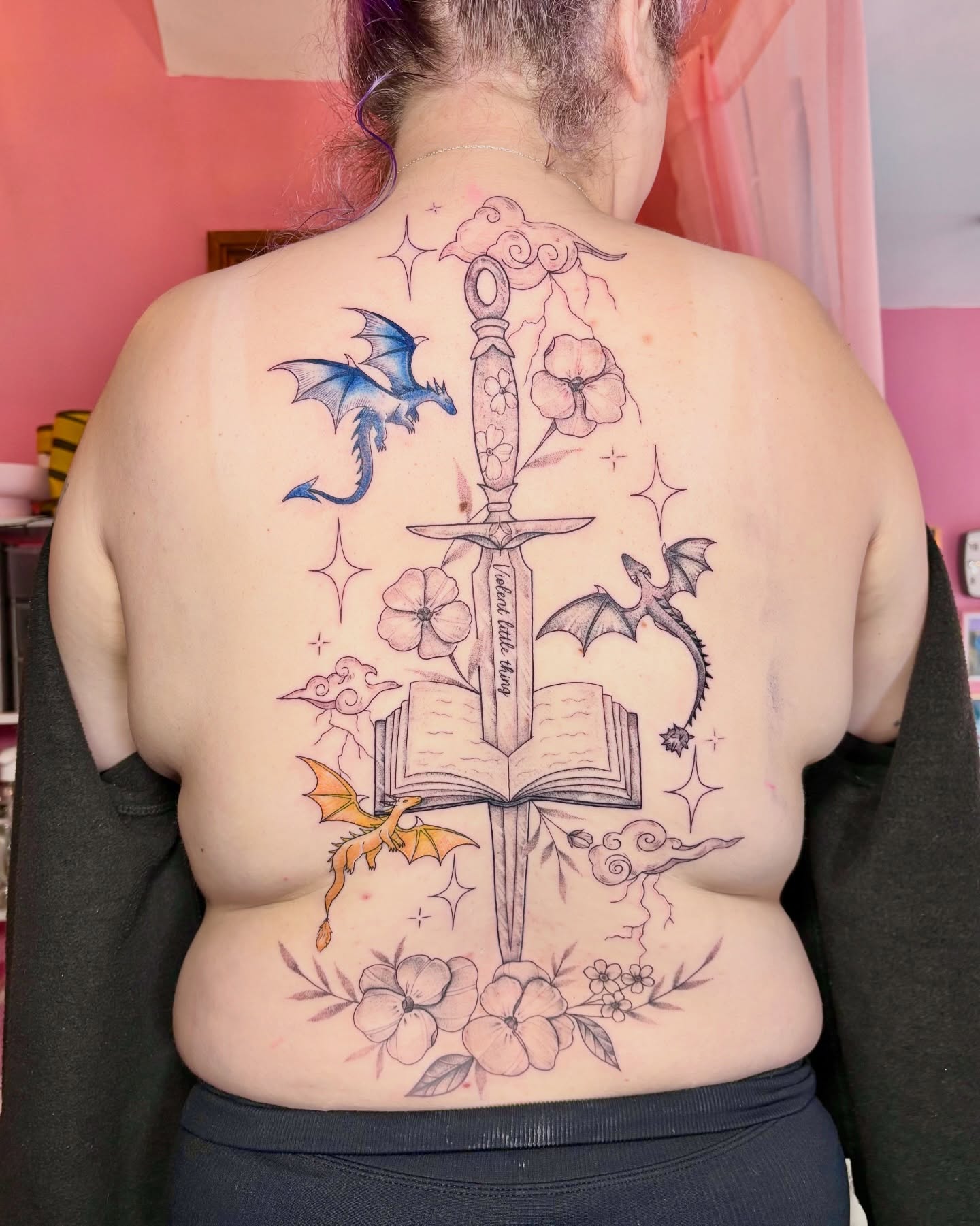 Book and sword new school tattoo on the back by Charlotte Brown, Leeds, England