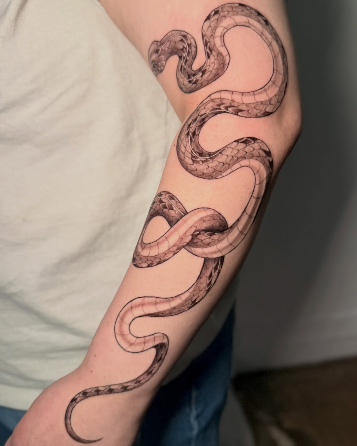 Snake black and grey tattoo on the forearm by Bradi