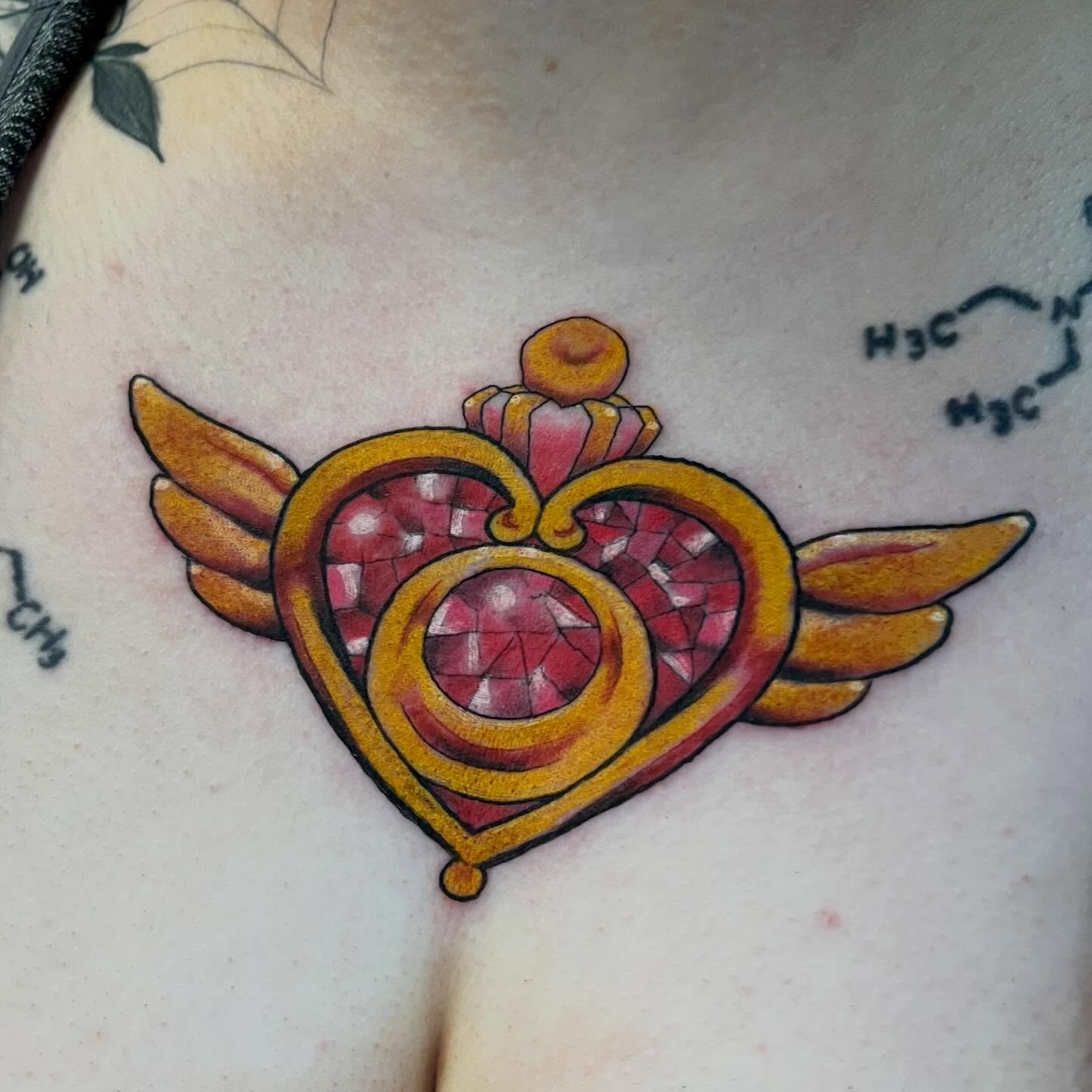 Heart with wings neo-traditional tattoo on the chest by Brianna Jo Ballinghoff