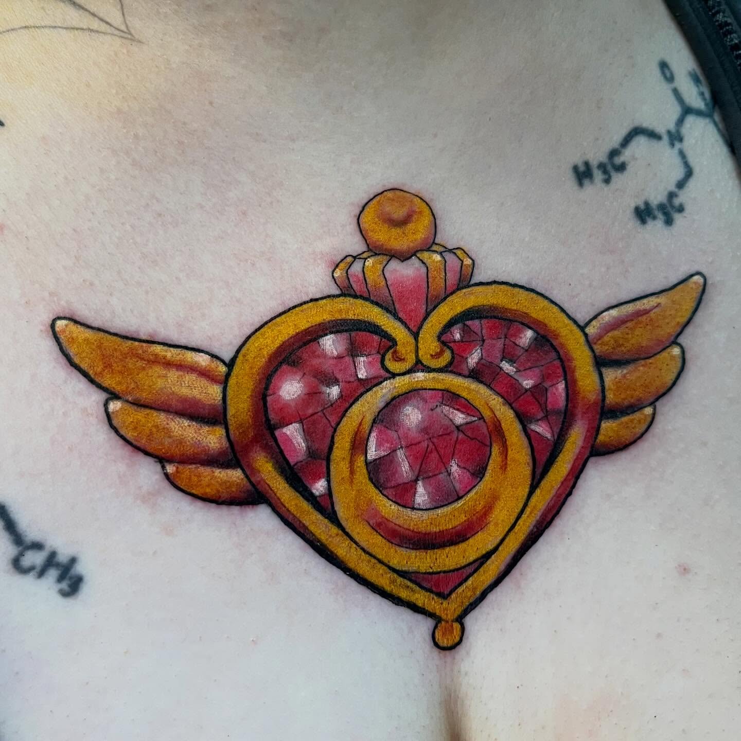 Heart with wings American traditional tattoo on the chest by Brianna Jo Ballinghoff
