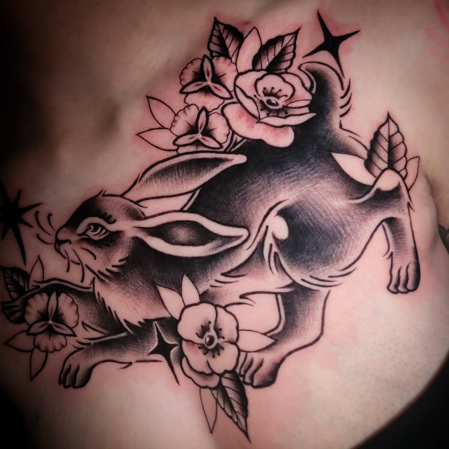 Rabbit and flowers American traditional tattoo on the chest by Randyz Tattyz