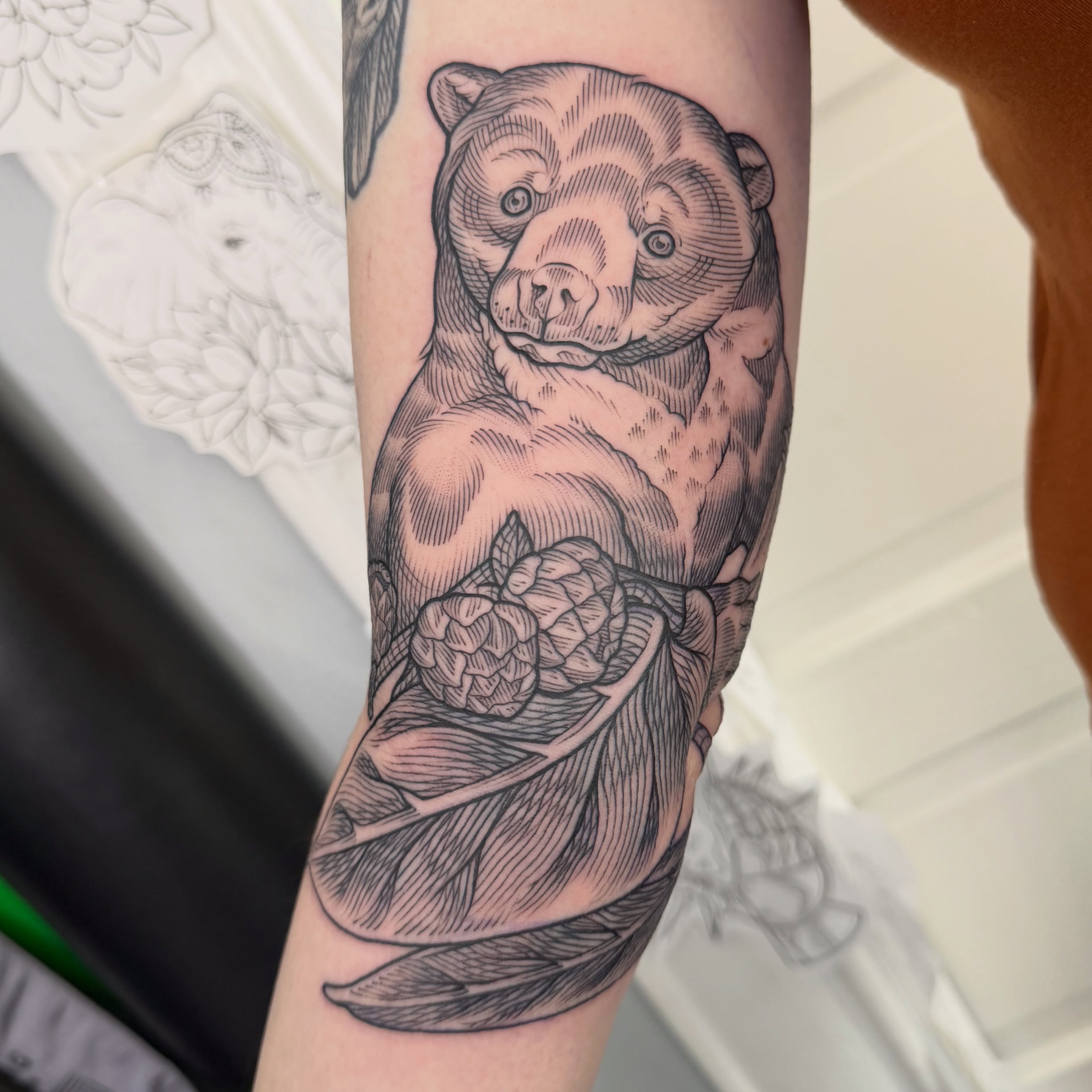 Bear holding hops black and grey tattoo on the forearm by Taylor 🍂☕️