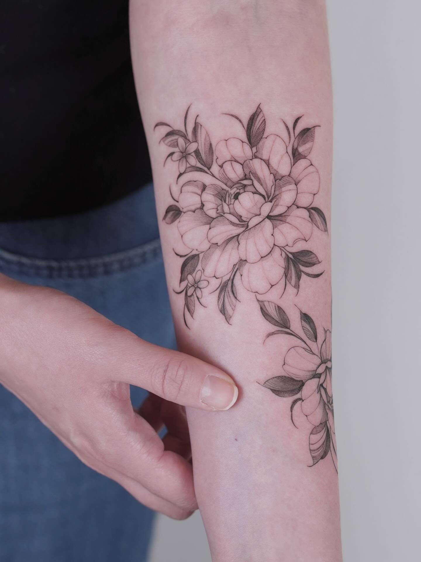 Peony flowers and leaves fine line tattoo on the forearm by Julia
