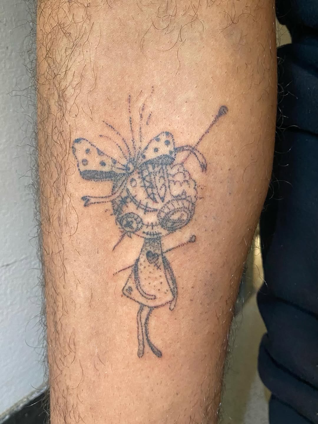 Creepy doll with butterfly bow sketch tattoo on the forearm by @feverfeverish