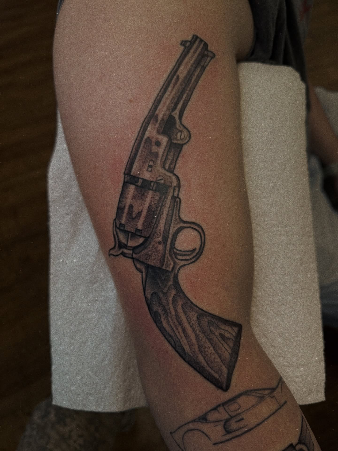Revolver black and grey tattoo on the forearm by Ramón Silva