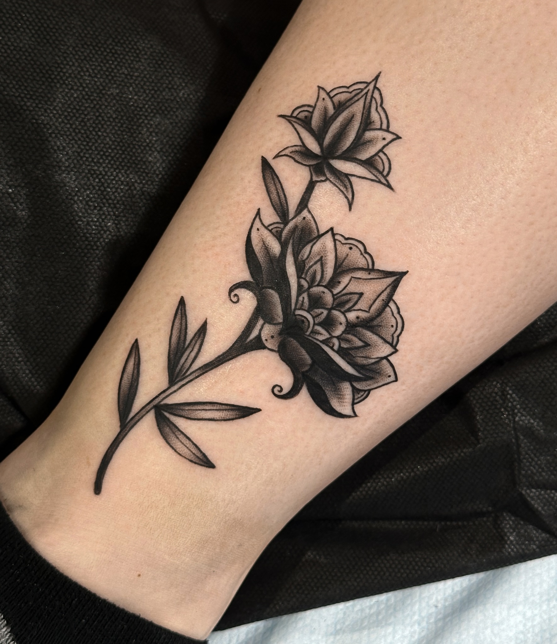 Flower bouquet black and grey tattoo on the forearm by Victoria