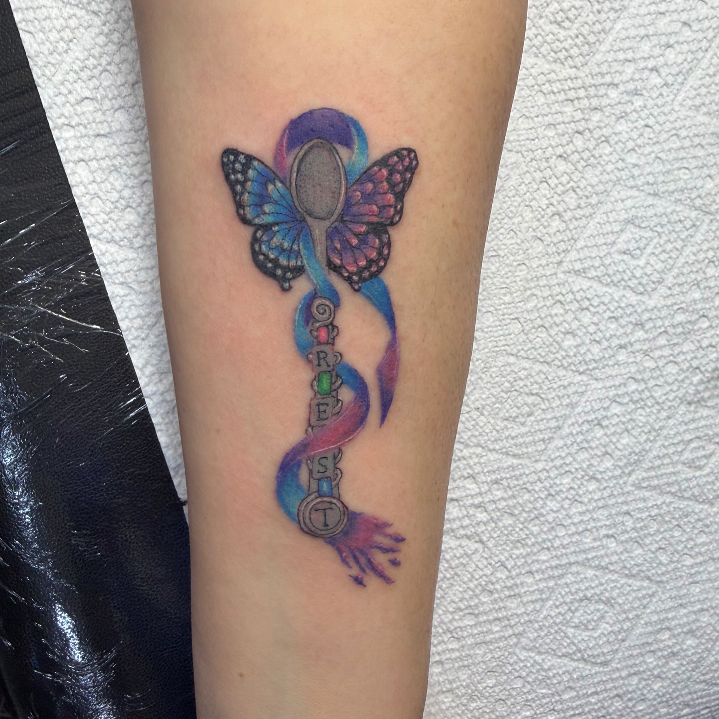 Butterfly and spoon new school tattoo on the forearm by Jinx Ryder