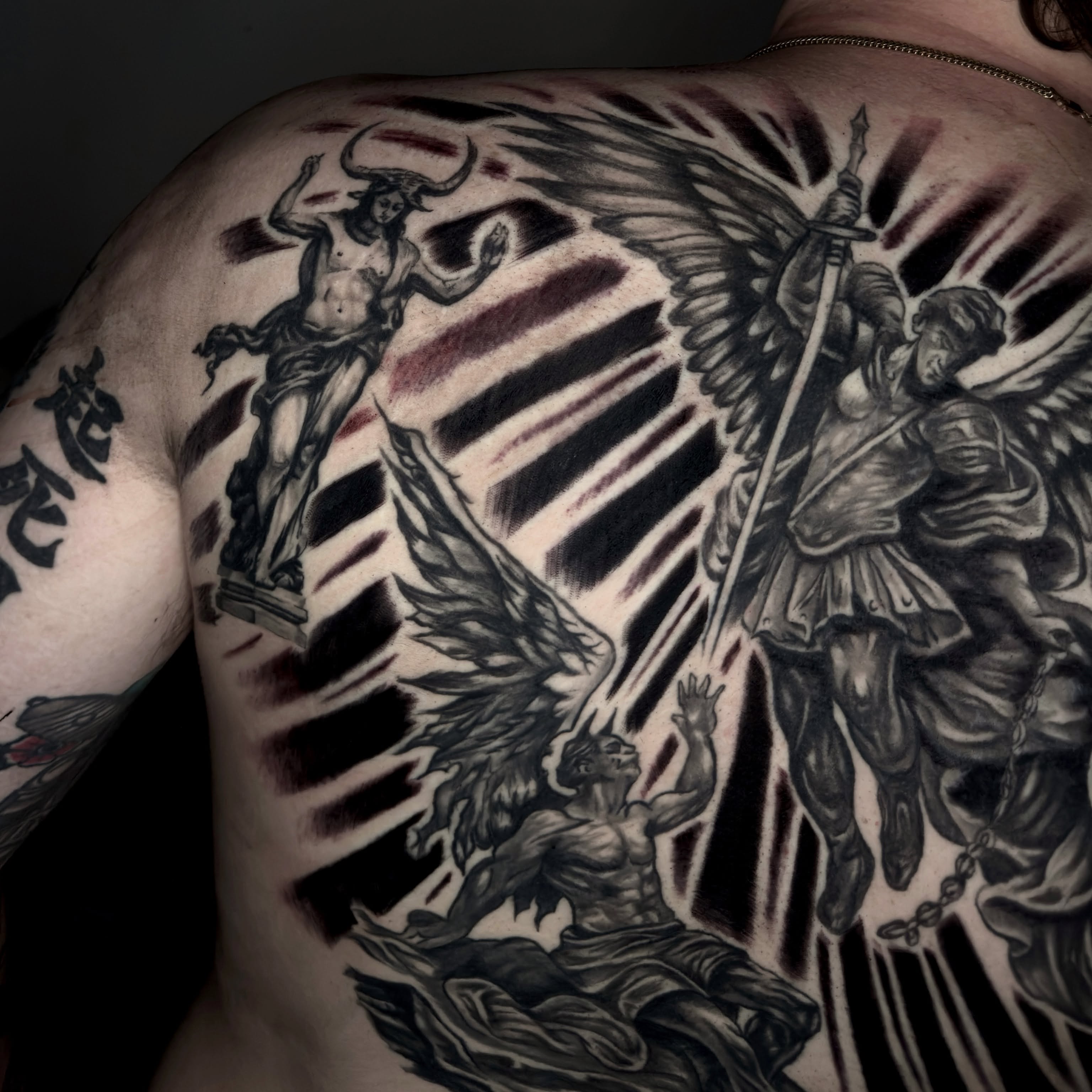 Angelic battle realism tattoo on the back by Butz Tattoos