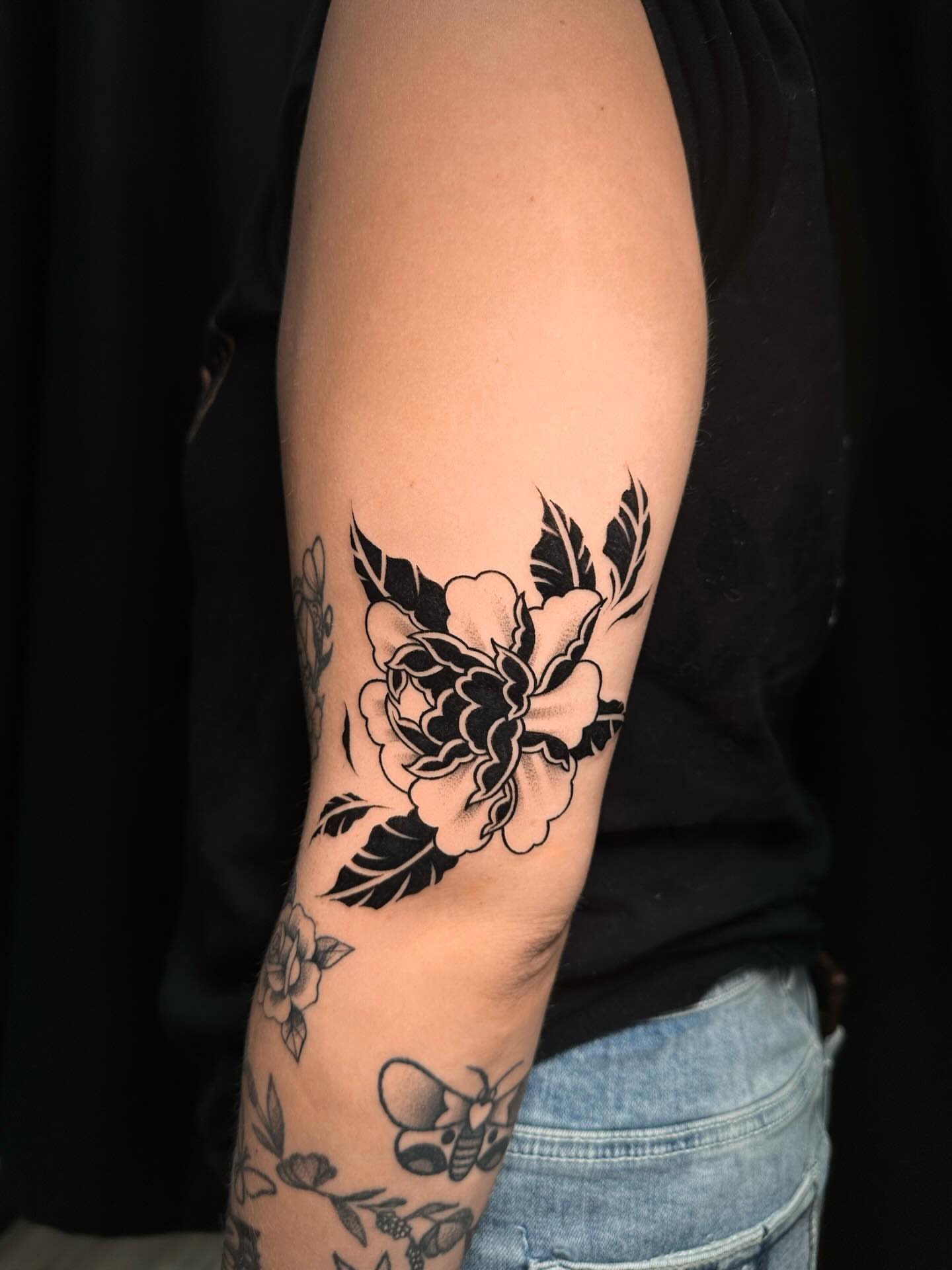 Peony American traditional tattoo on the forearm by Frida Tattooista