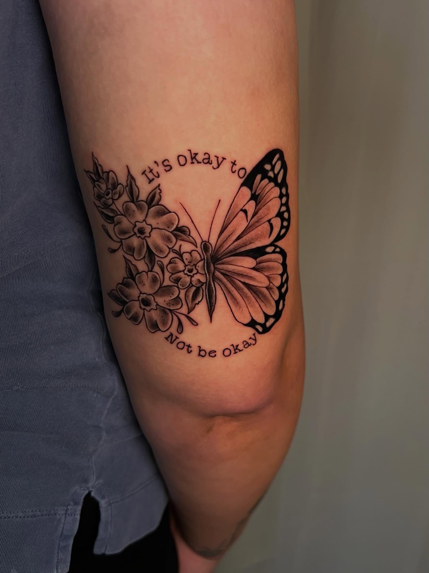 Butterfly and flowers black and grey tattoo on the forearm by Jessica Kloos