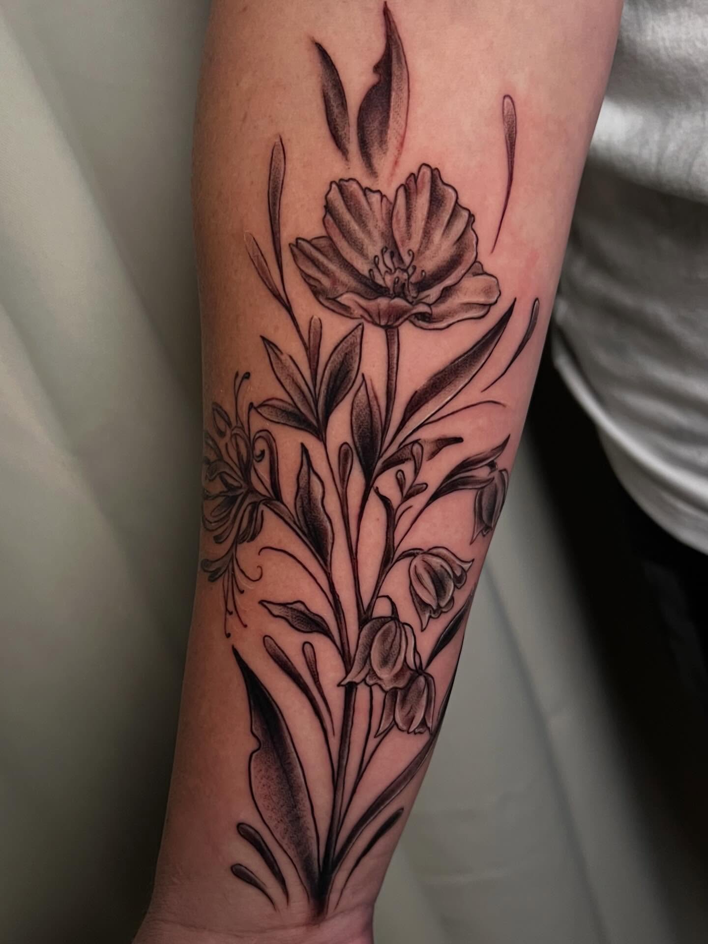 Floral arrangement black and grey tattoo on the forearm by Jessica Kloos