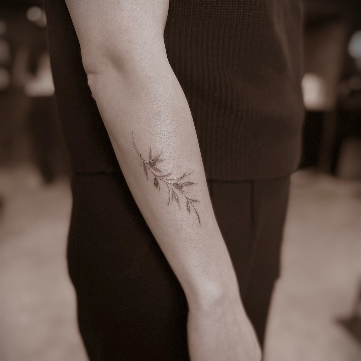 Olive branch fine line tattoo on the forearm by Chanel Picquelle, Nashville, Tennessee