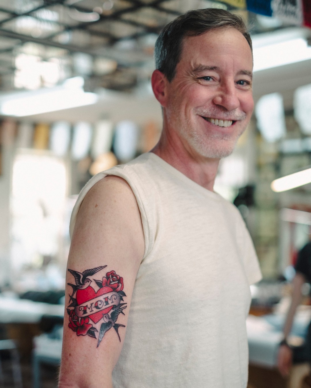 Heart with roses American traditional tattoo on the upper arm by Dan Gilsdorf, Portland, Oregon