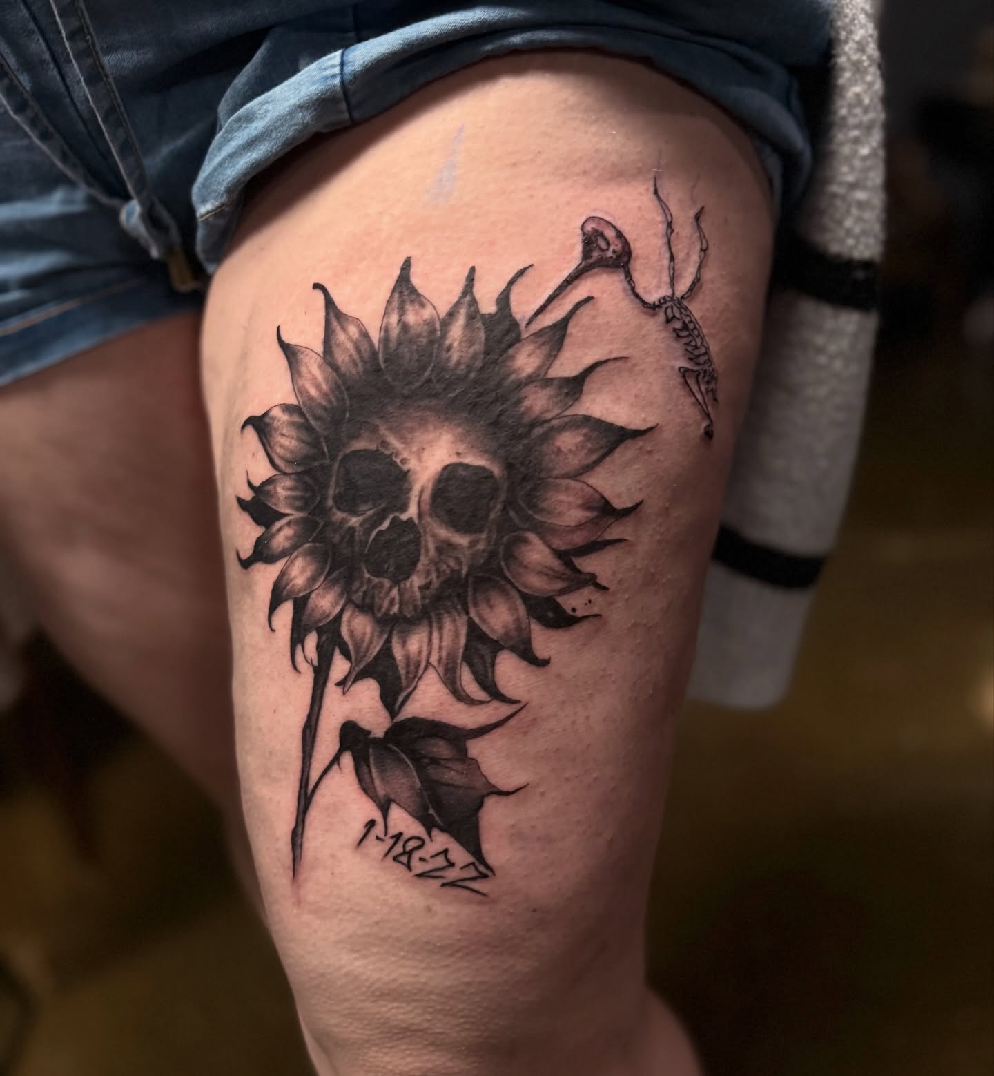 Sunflower skull dark realism tattoo on the thigh by Miles Haysmith