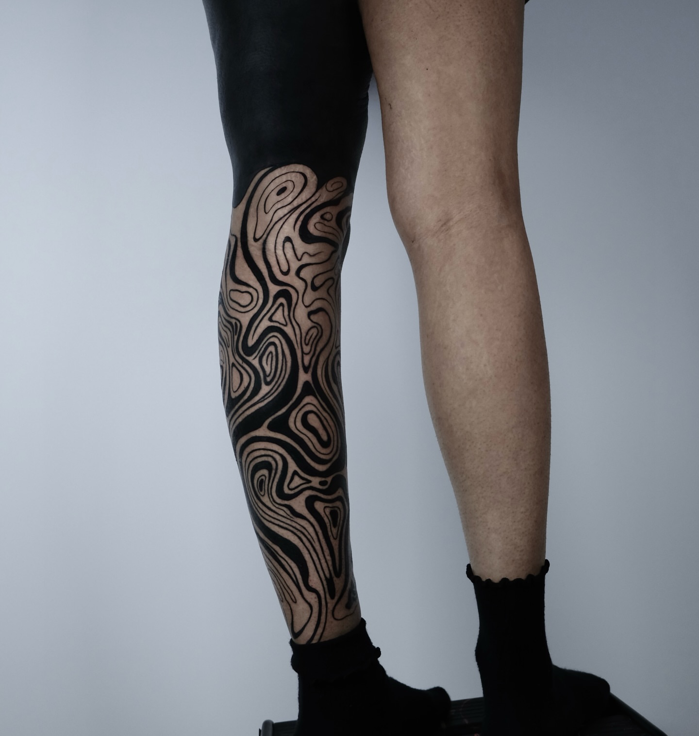 Abstract pattern black and grey tattoo on the calf by Eric Hare