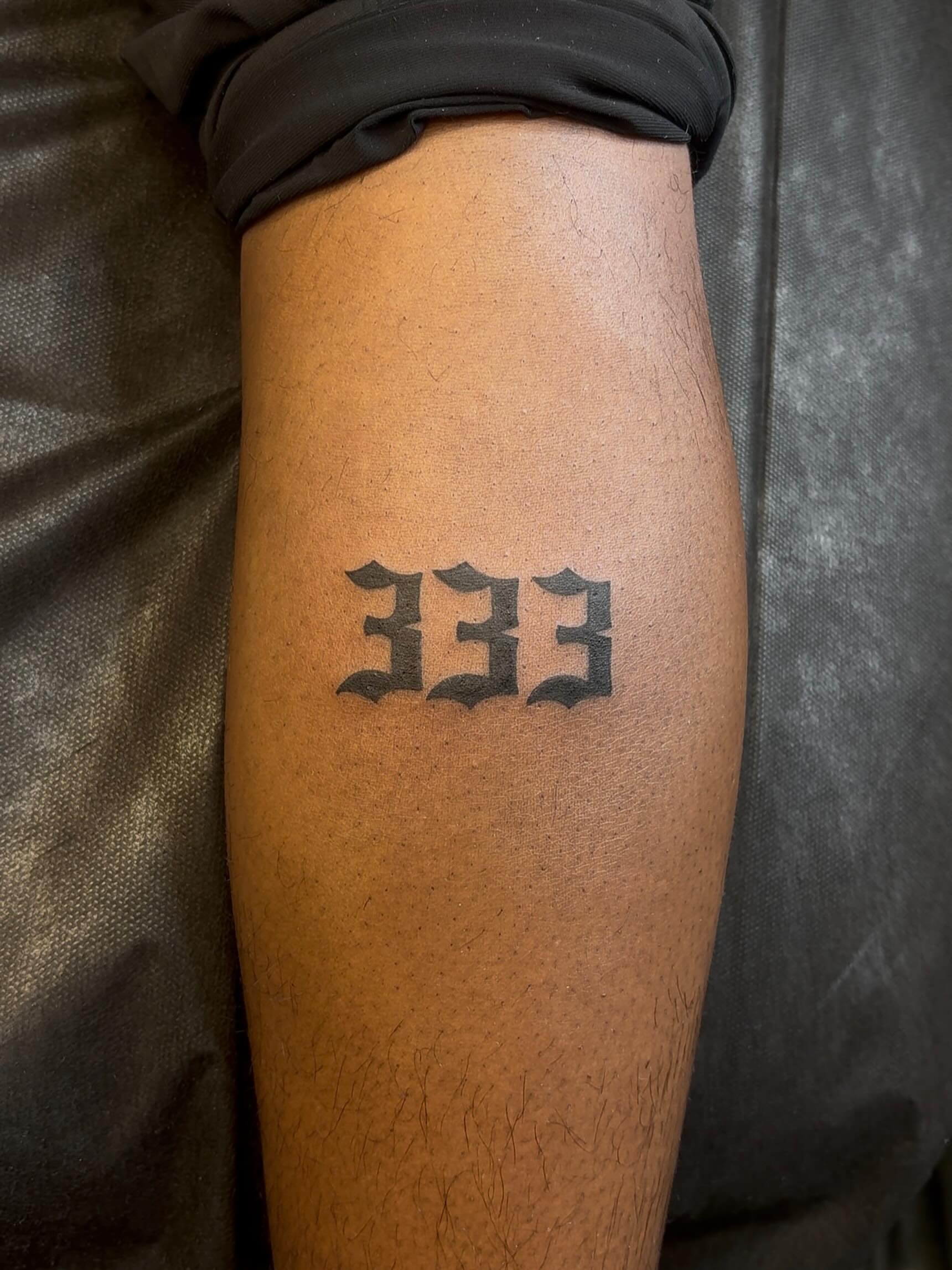 Number 333 lettering script tattoo on the forearm by alana khounmeuang