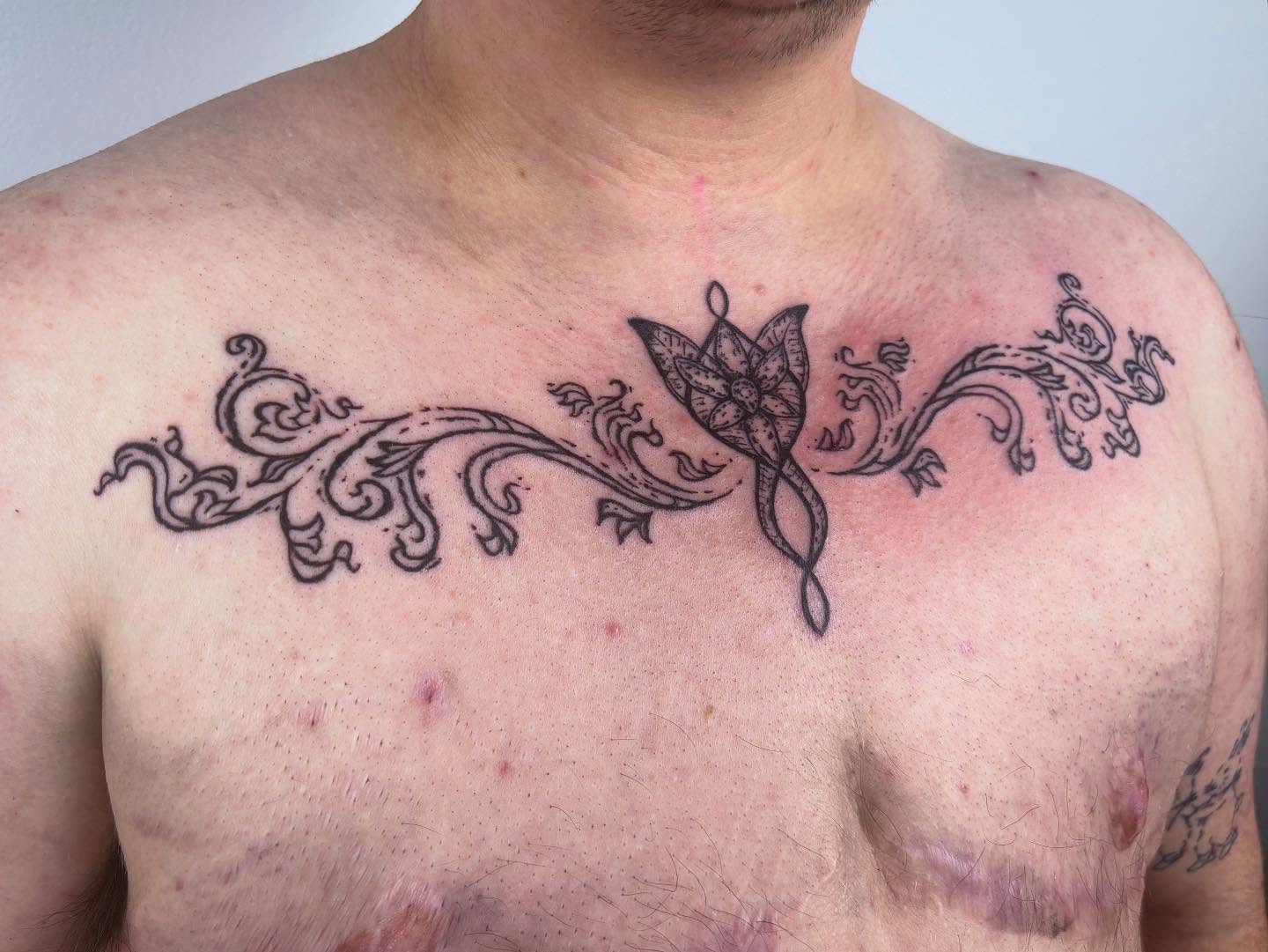 Butterfly and floral vine ornamental tattoo on the chest by kendle
