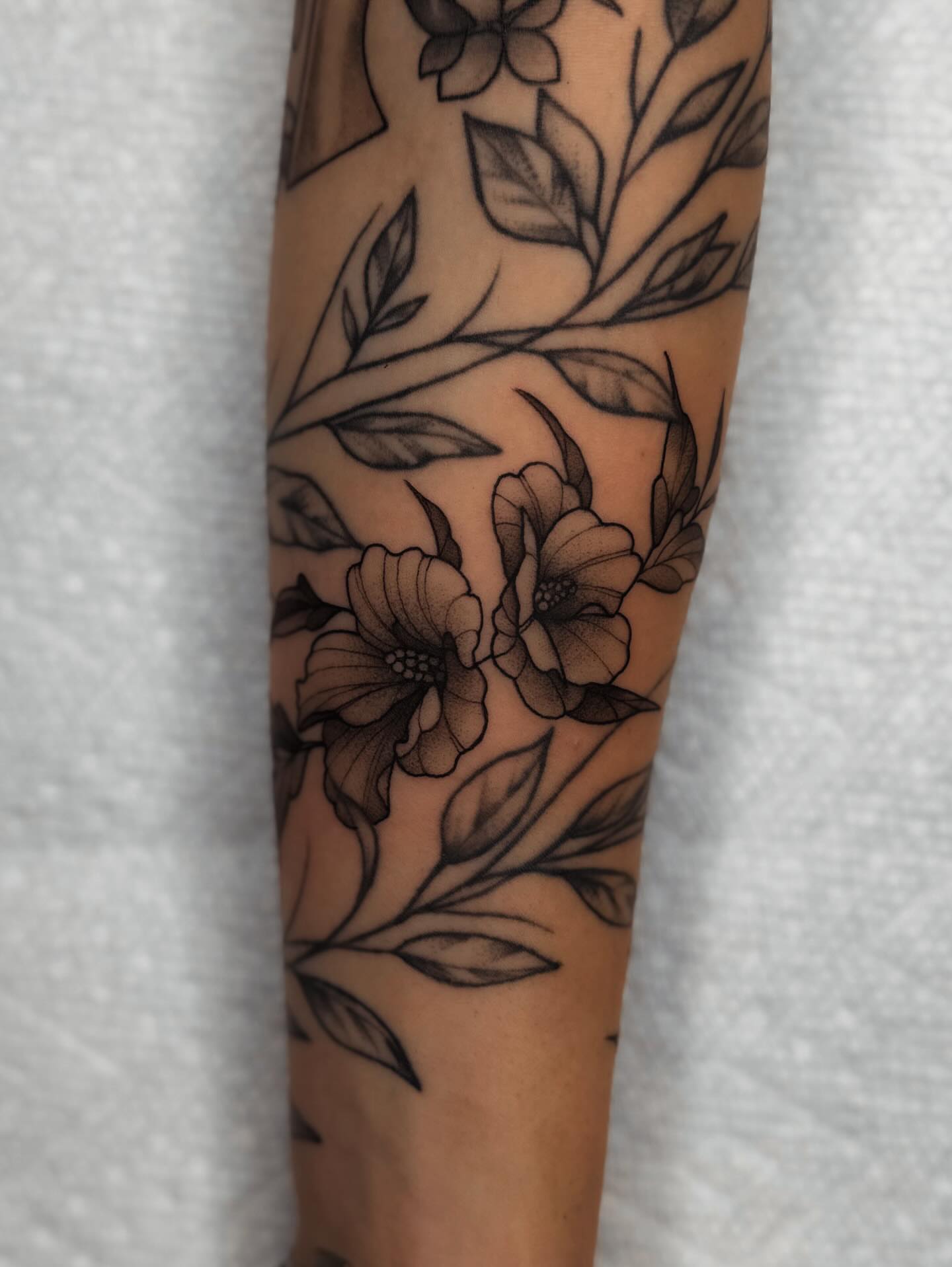 Floral design black and grey tattoo on the forearm by 𝔍𝔞𝔯𝔢𝔡 𝔞𝔩𝔩𝔢𝔫