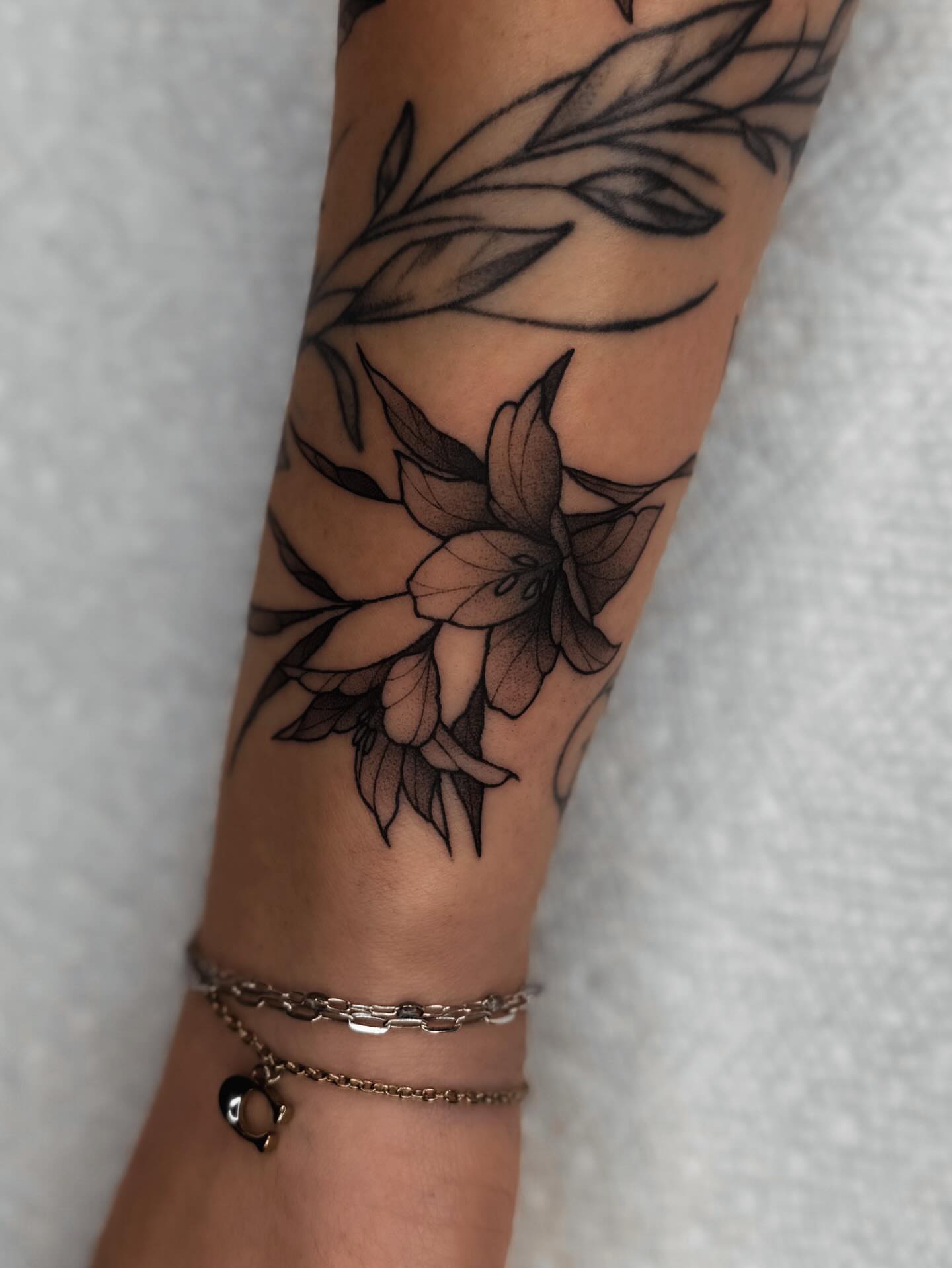 Lily flowers black and grey tattoo on the forearm by 𝔍𝔞𝔯𝔢𝔡 𝔞𝔩𝔩𝔢𝔫