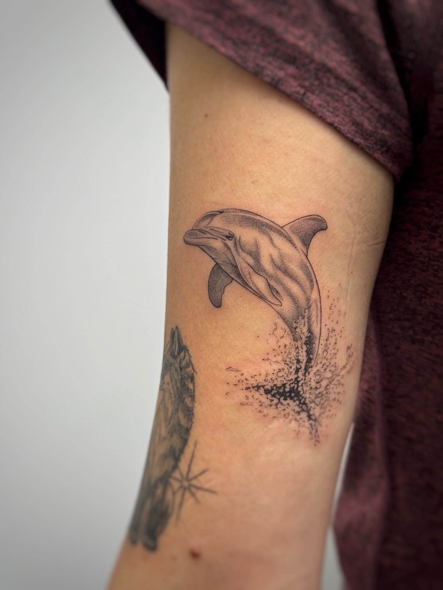 Dolphin dotwork tattoo on the forearm by Lea Burkard, Berkeley, California