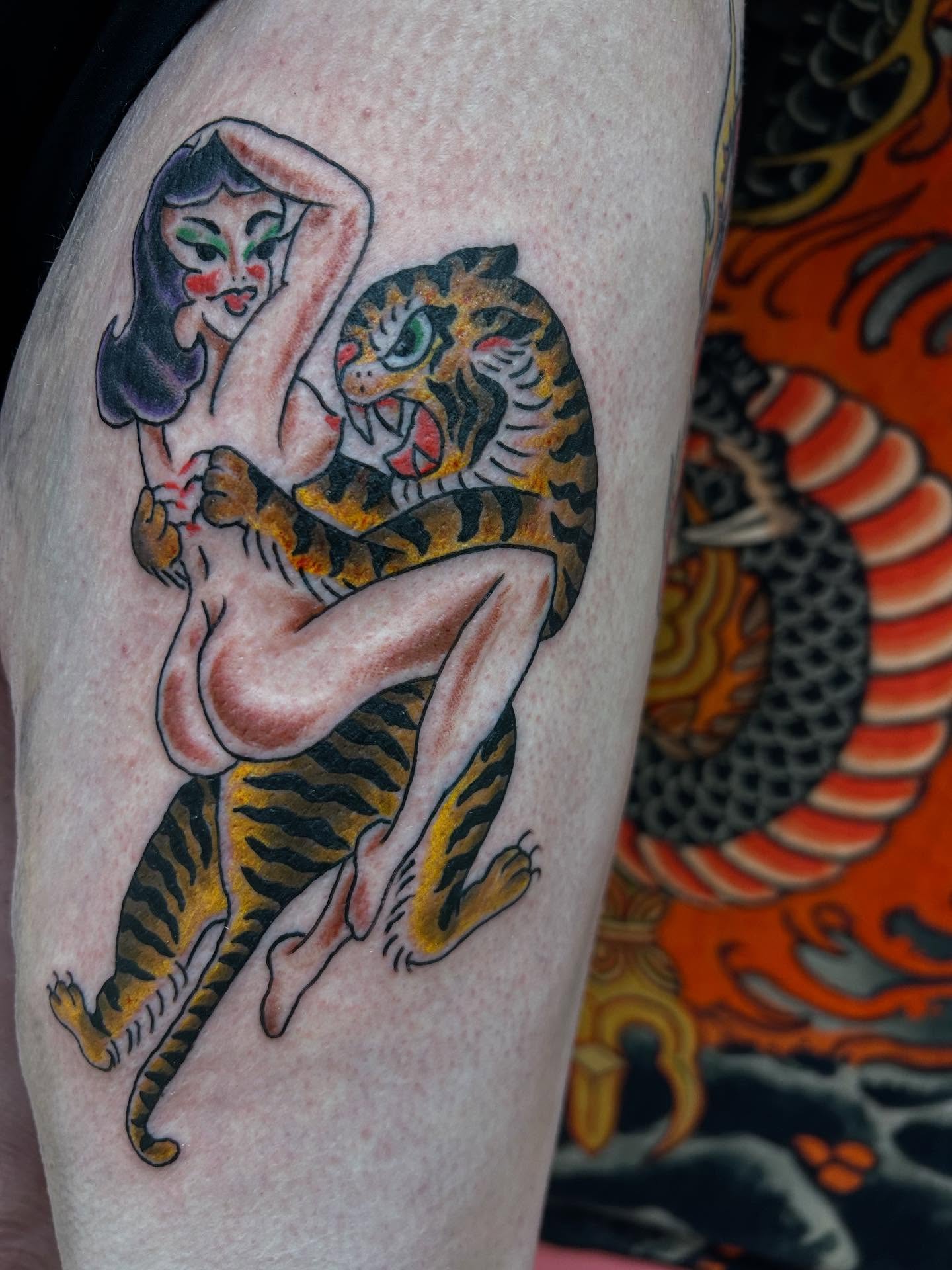 Woman with tiger American traditional tattoo on the thigh by Stogie Tony