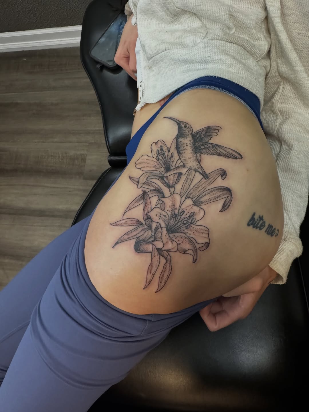 Hummingbird and lilies fine line tattoo on the thigh by Lexy
