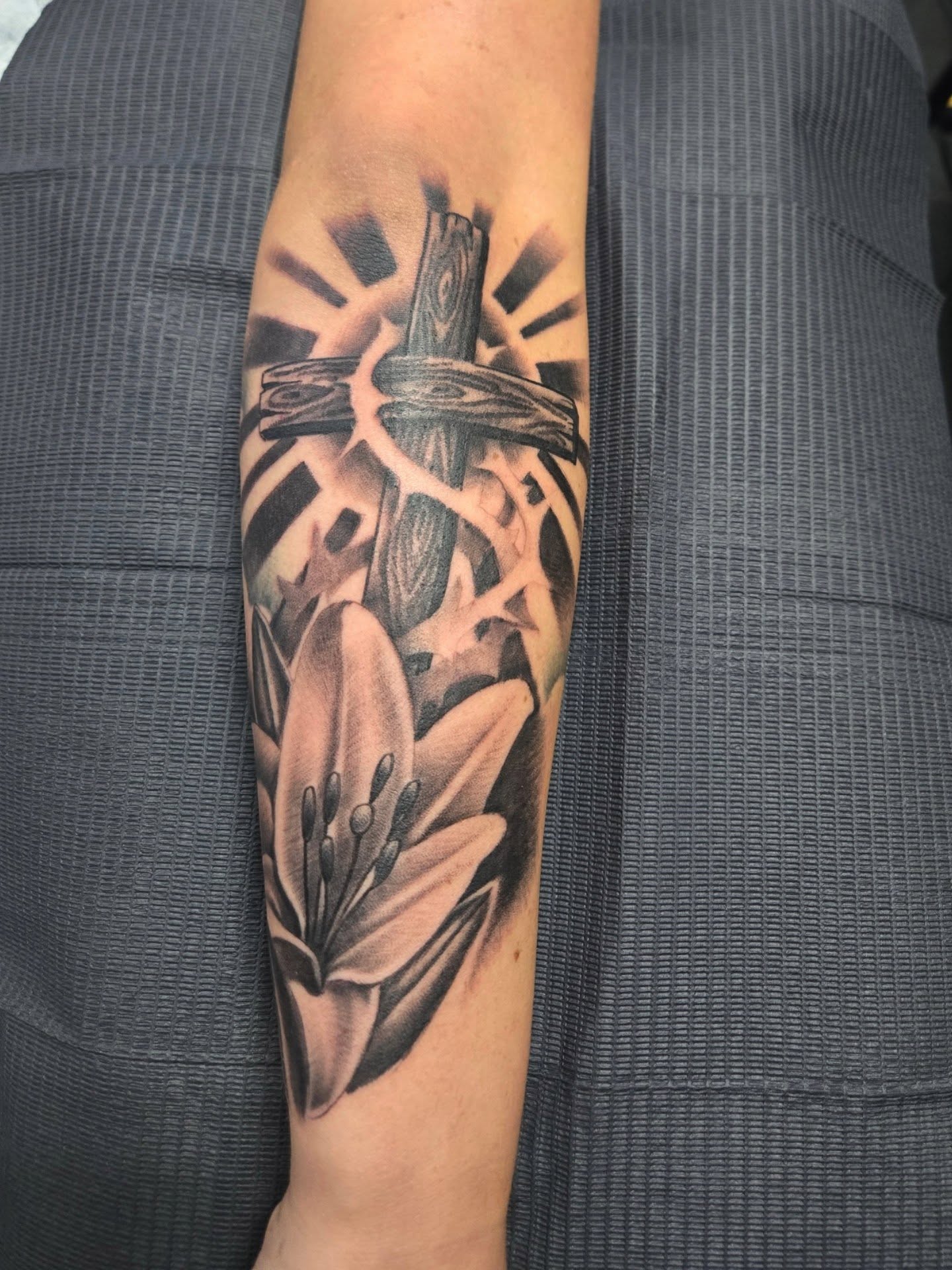 Cross and lily black and grey tattoo on the forearm by Cee Vann, Greensboro, North Carolina
