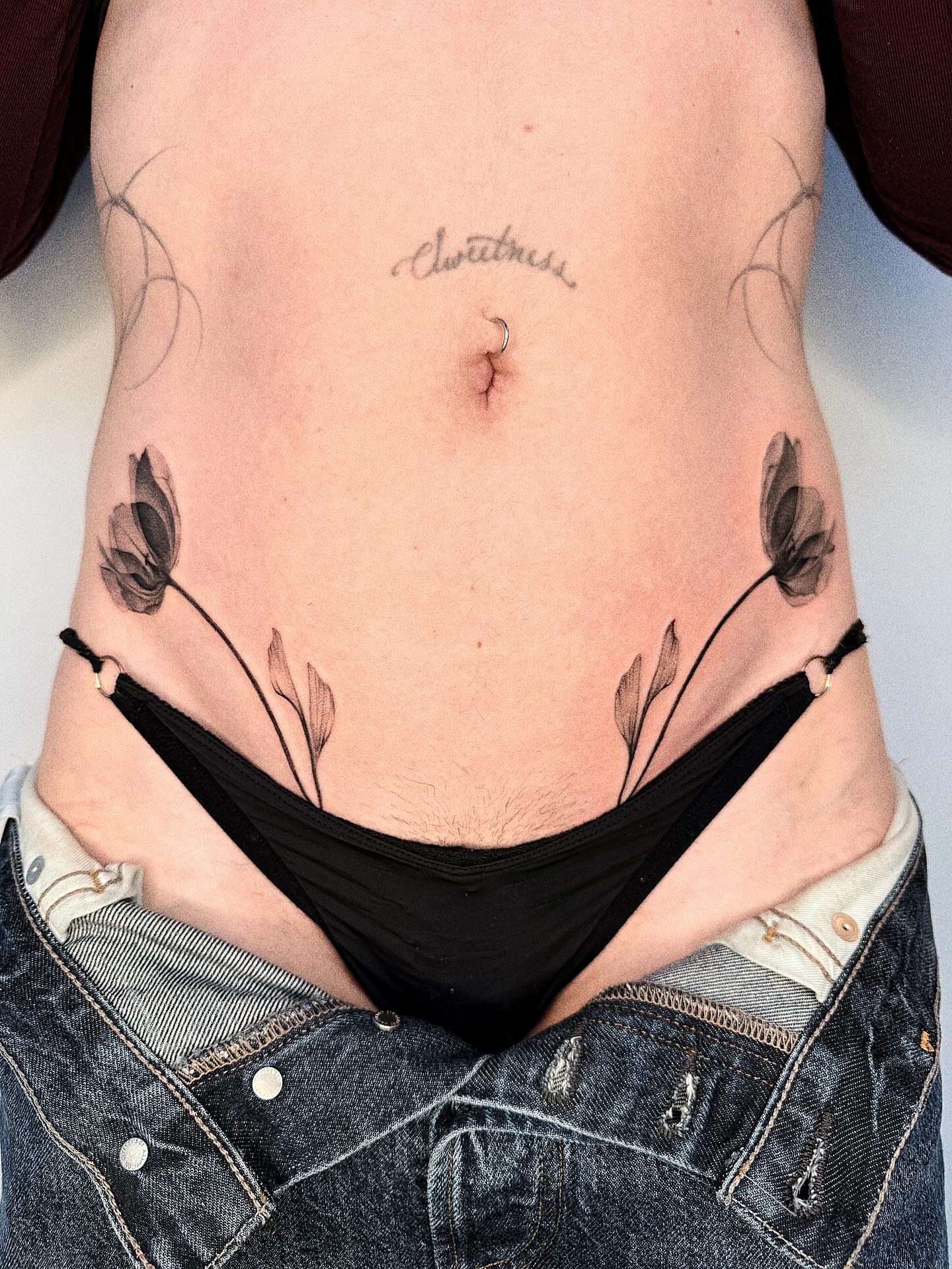Floral black and grey tattoo on the torso by Jenni Palomaa