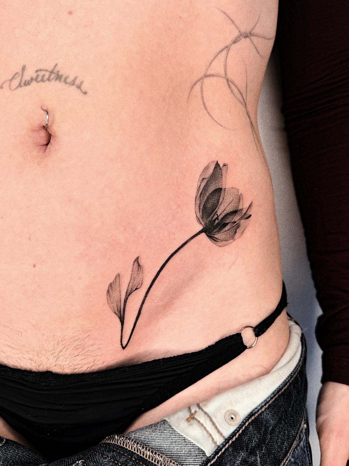 Flower black and grey tattoo on the ribs by Jenni Palomaa
