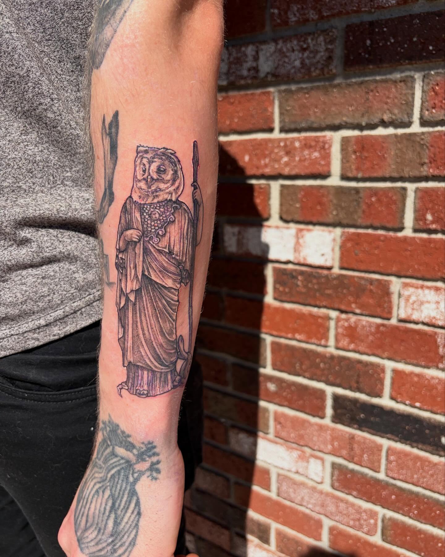 Owl in robe black and grey tattoo on the forearm by Emily Falkowski