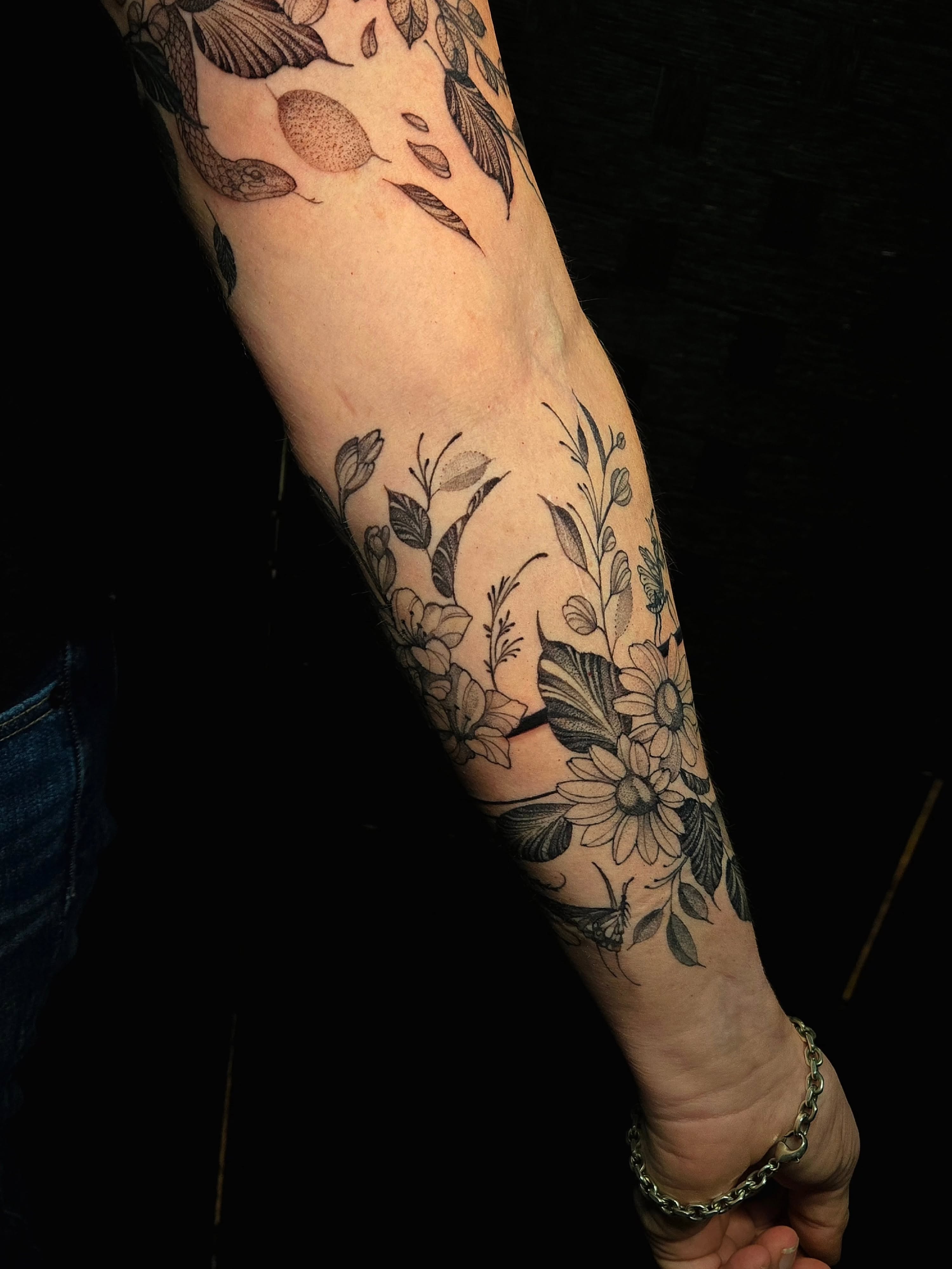Floral arrangement black and grey tattoo on the forearm by Jesseca Chinchilla