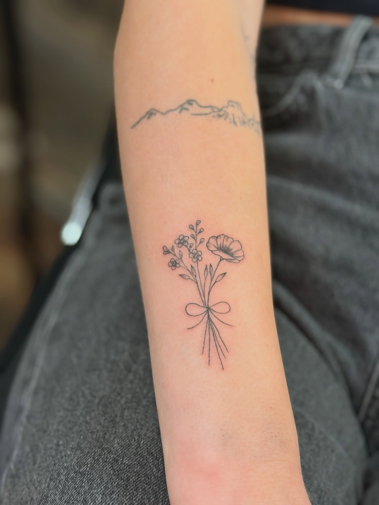 Flower bouquet minimalist tattoo on the forearm by JAmy Winters