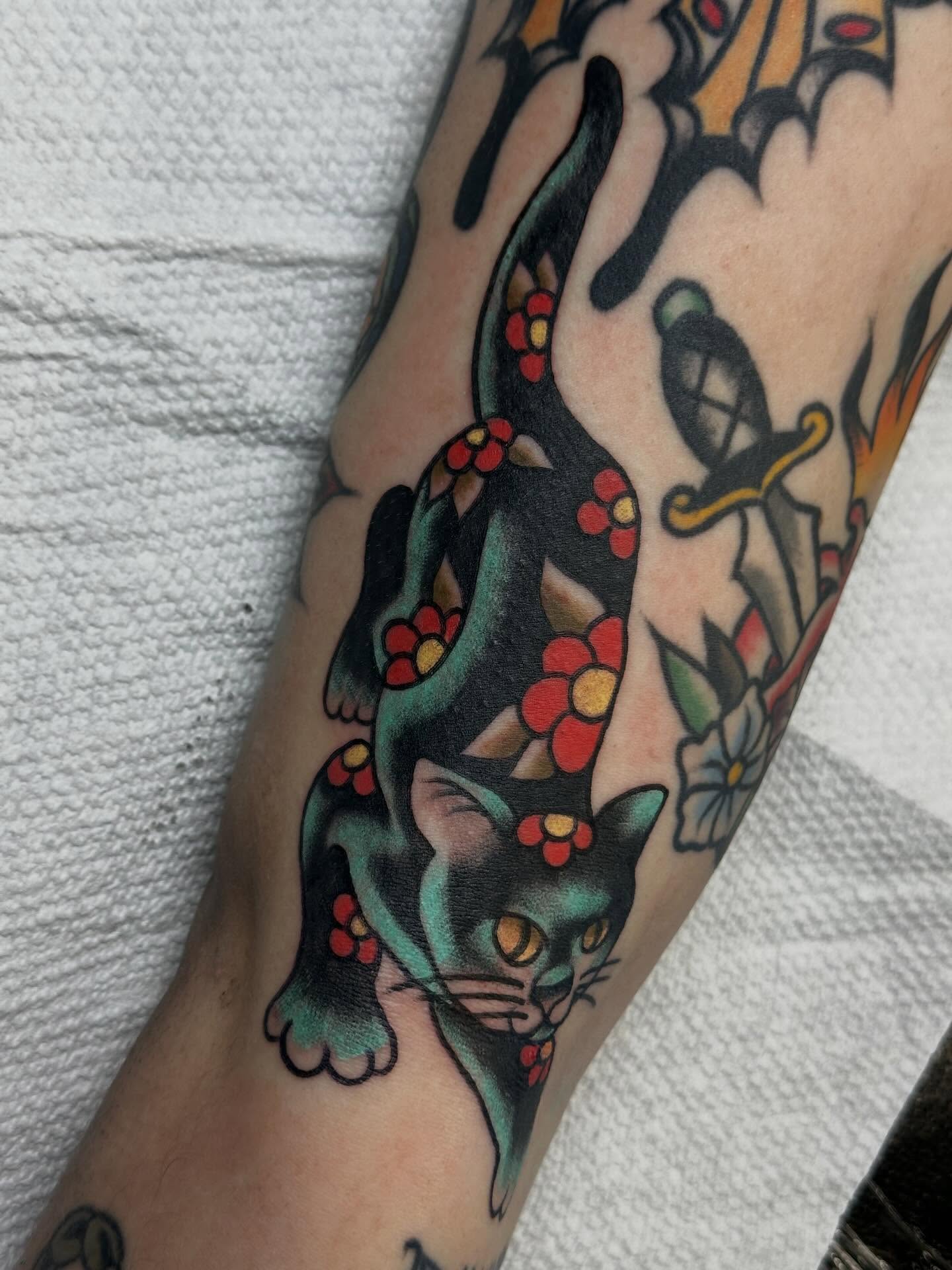 Cat with flowers American traditional tattoo on the forearm by Elisha B🦷