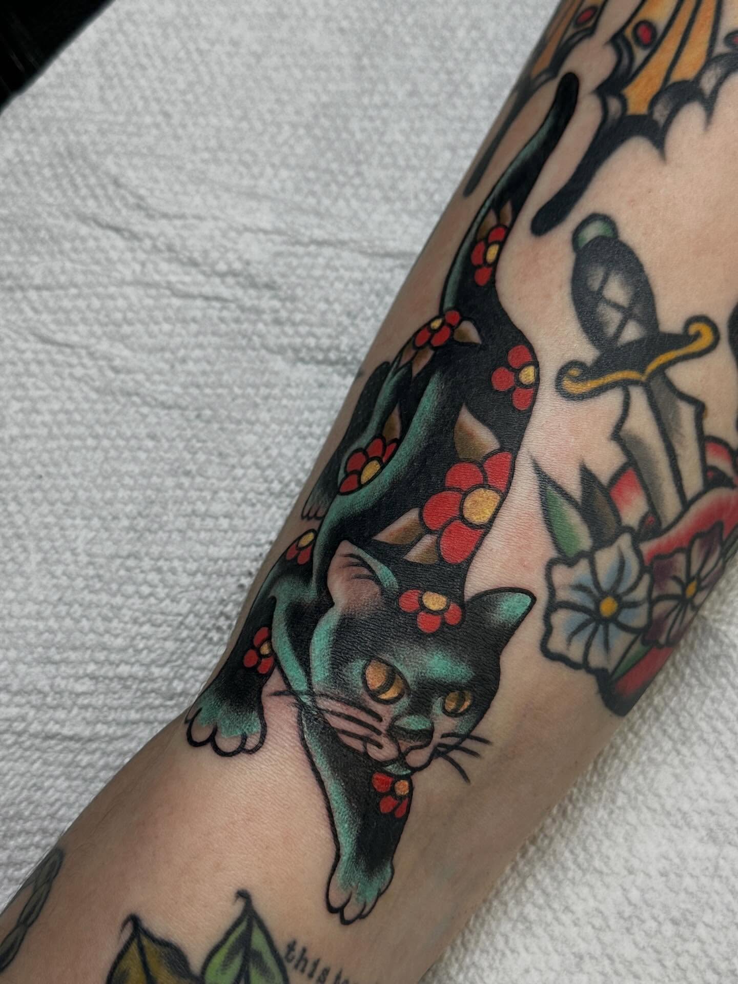 Cat with flowers American traditional tattoo on the forearm by Elisha B🦷