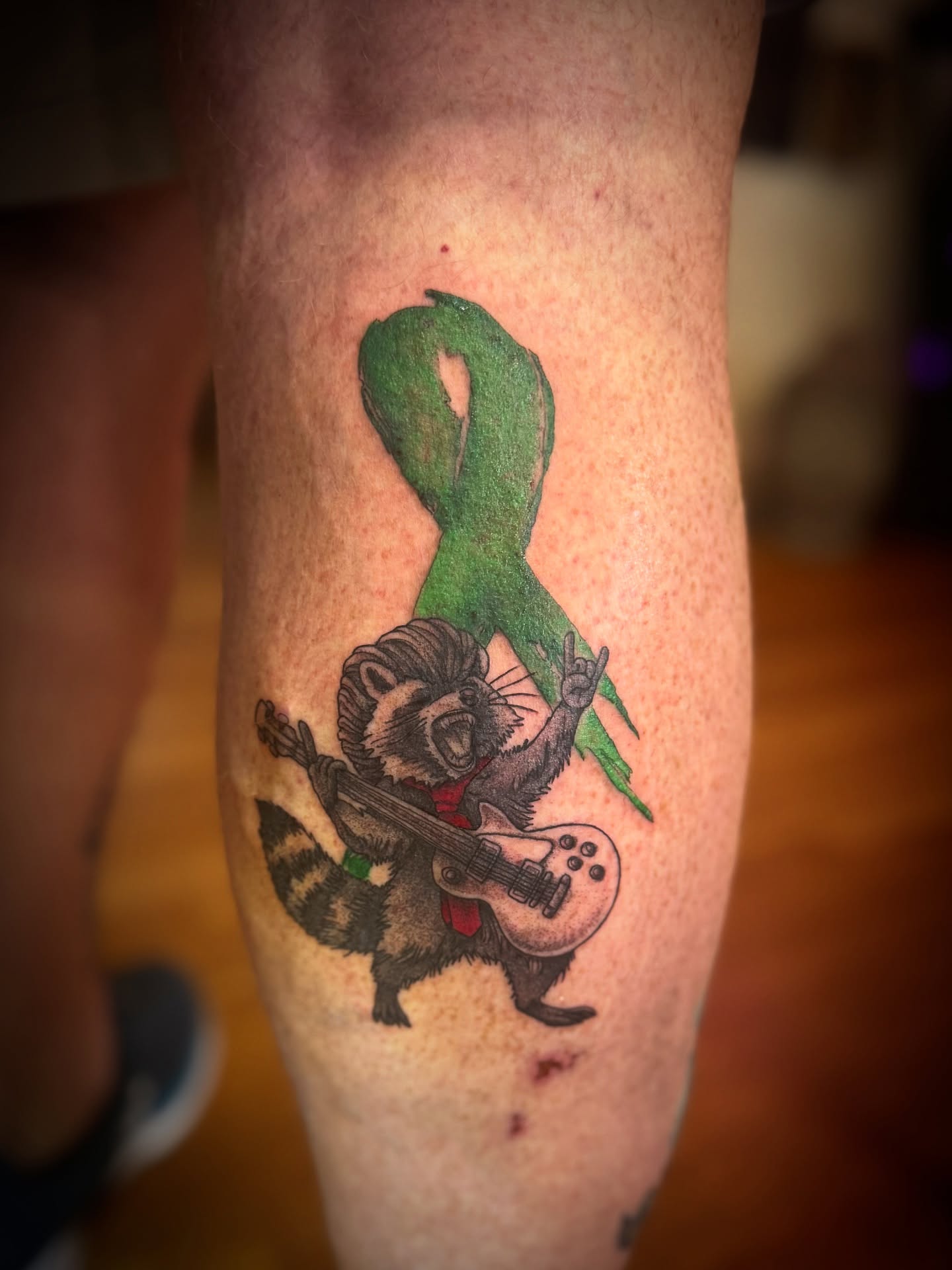 Raccoon playing guitar new school tattoo on the forearm by Gianna G