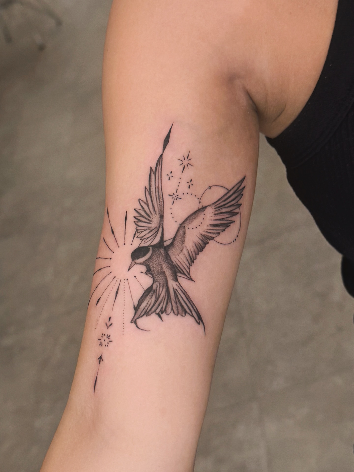 Swallow and celestial elements black and grey tattoo on the forearm by MJ