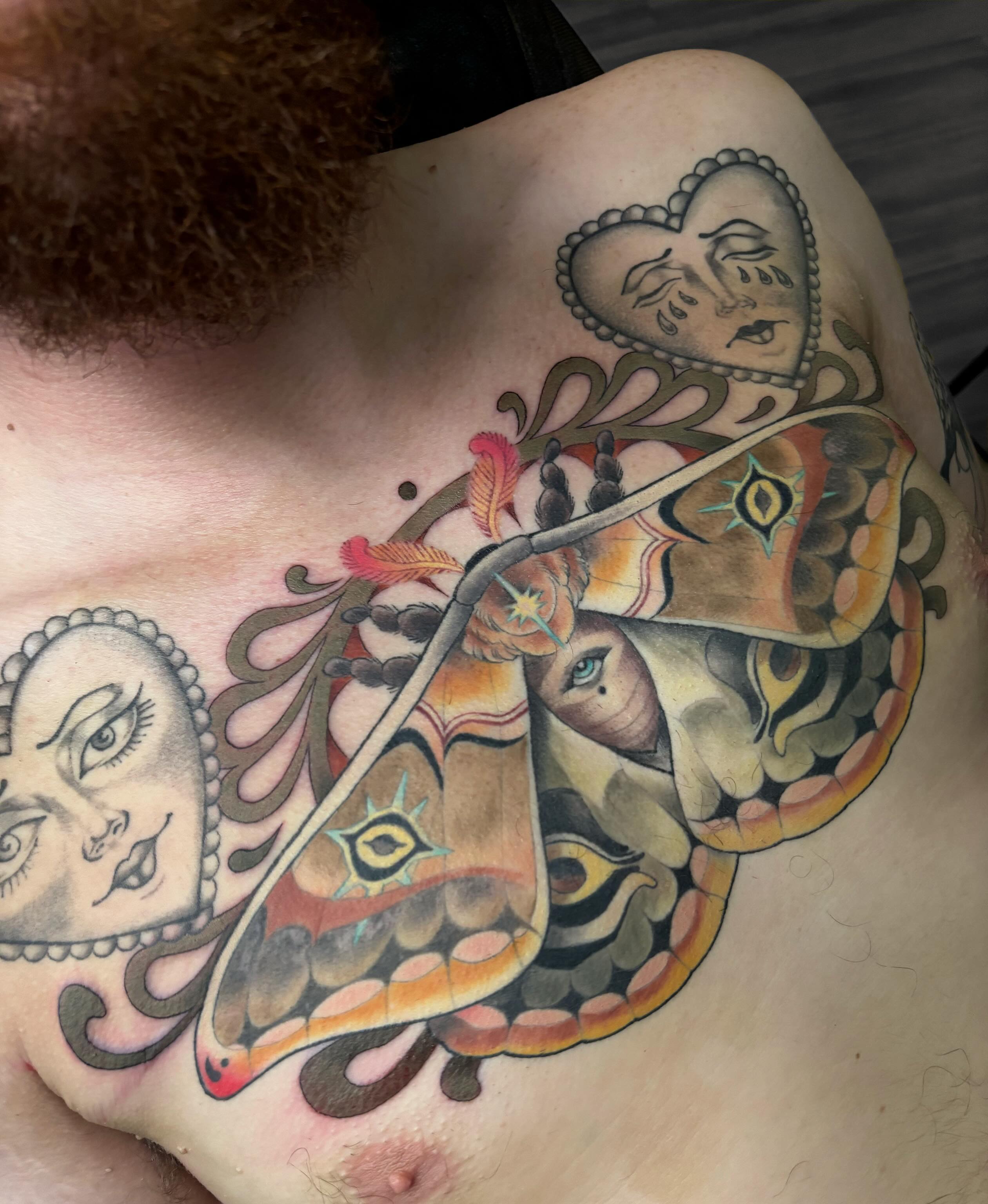 Moth and faces American traditional tattoo on the chest by Alex