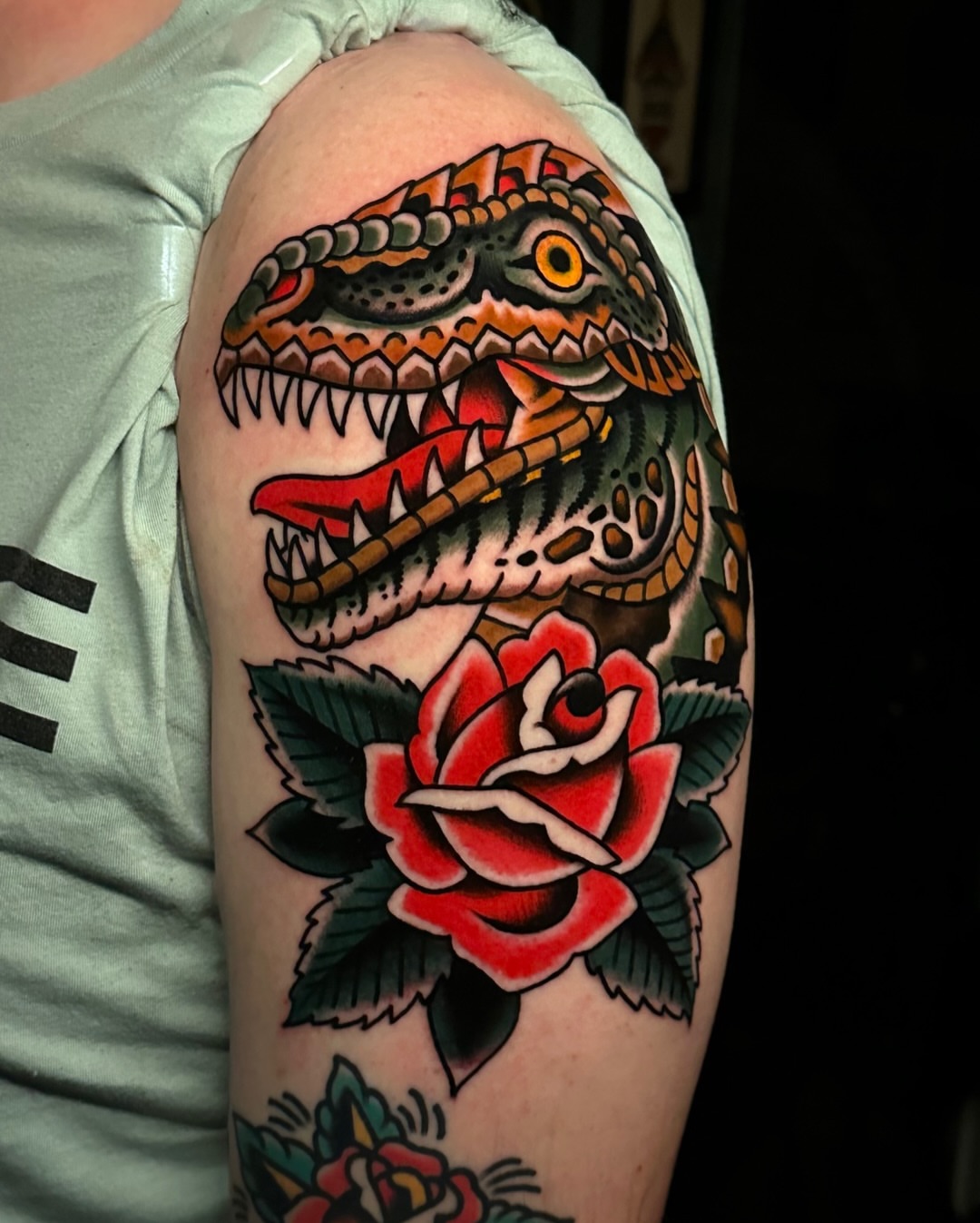 Dinosaur and rose American traditional tattoo on the forearm by Tony Perez- Austin Texas Tattooer