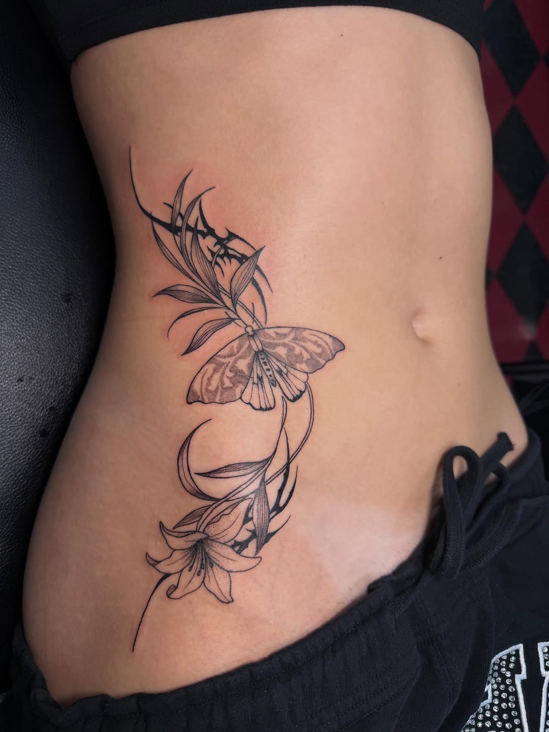 Moth and lily cyber sigilism tattoo on the ribs by 𝕯𝖆𝖓𝖎
