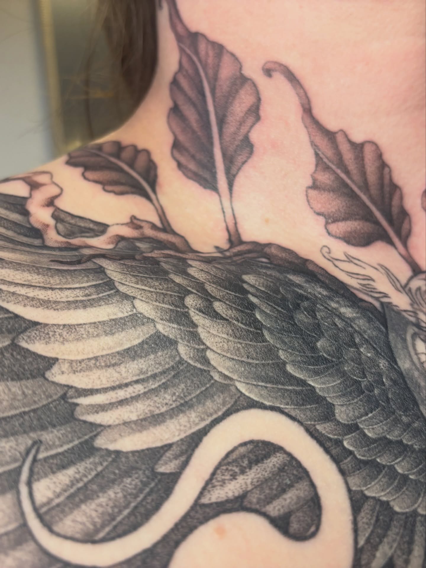 Bird and leaves black and grey tattoo on the neck by Rachel Foster
