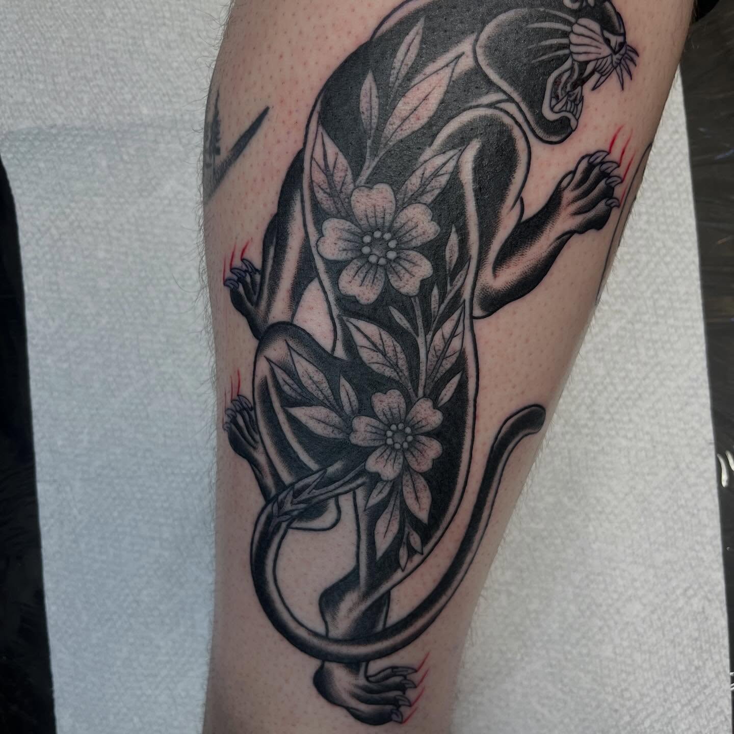 Panther and flowers black and grey tattoo on the forearm by Evan Voelker